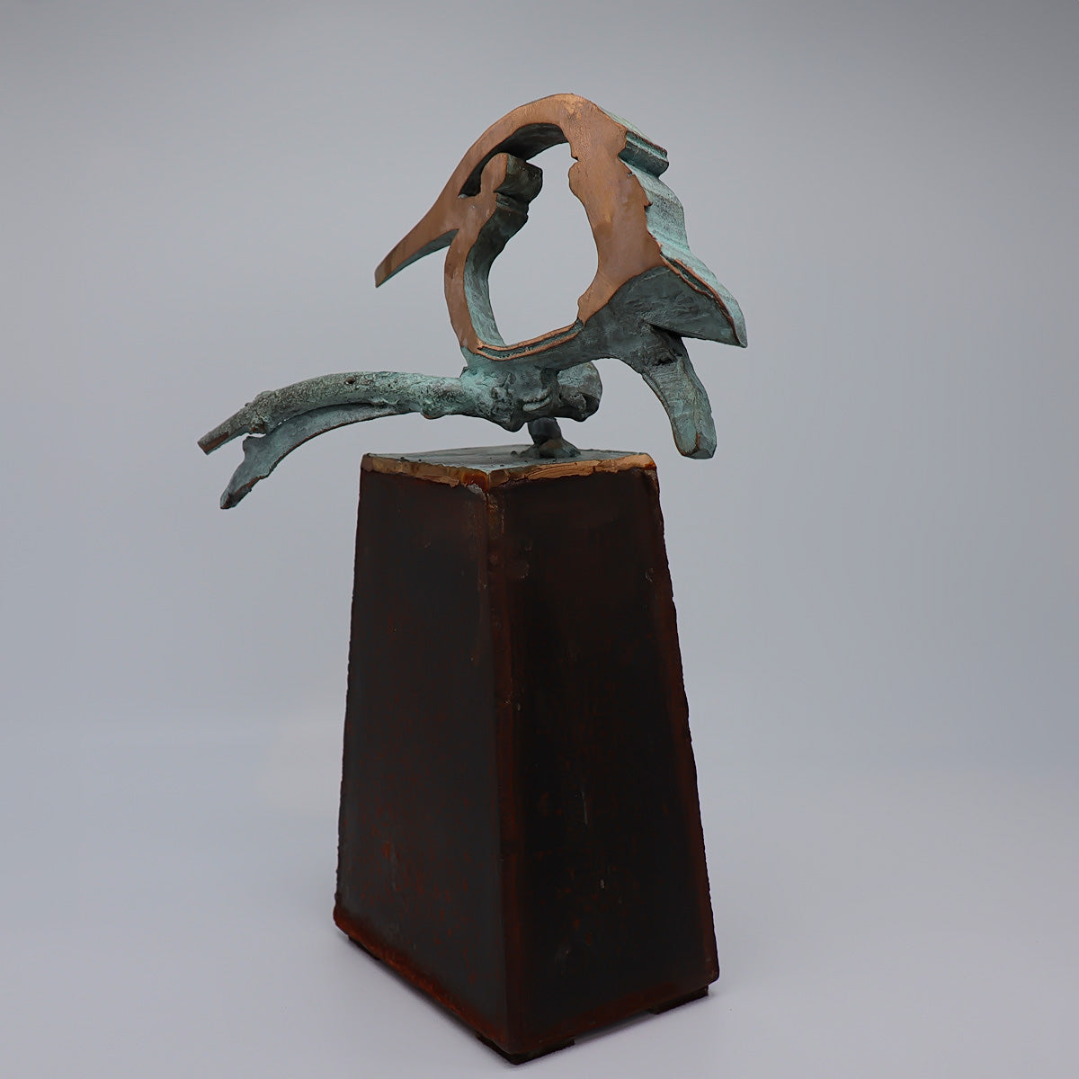 Elegante midi urn van JEART met bronzen ijsvogel vrede op een tak, geplaatst op een cortensokkel. Duurzame materialen symboliseren kracht en eeuwigheid, terwijl de ijsvogel staat voor hoop en nieuwe beginnen. Een stijlvolle en betekenisvolle herinnering.