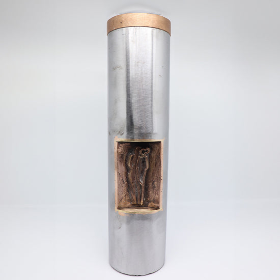 Blank stalen midi urn van JEART met een bronzen dop en inleg, symboliserend "samen op pad". De combinatie van staal en brons staat voor kracht en verbondenheid, een stijlvolle herinnering aan de gedeelde levensreis.